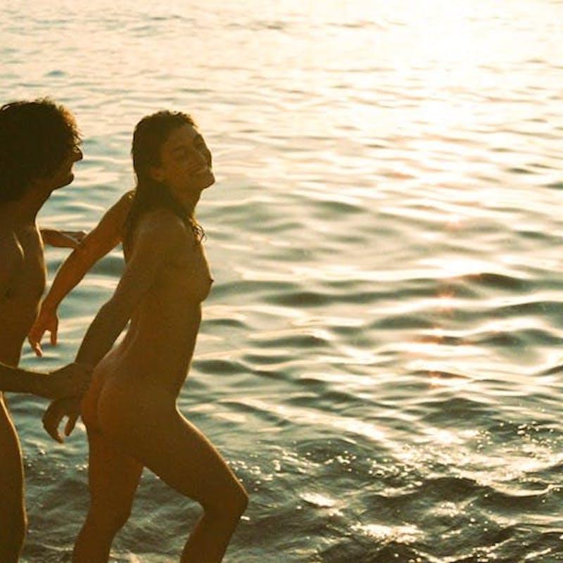9P A morena europeia Julia Roca posa nua com o namorado em uma praia