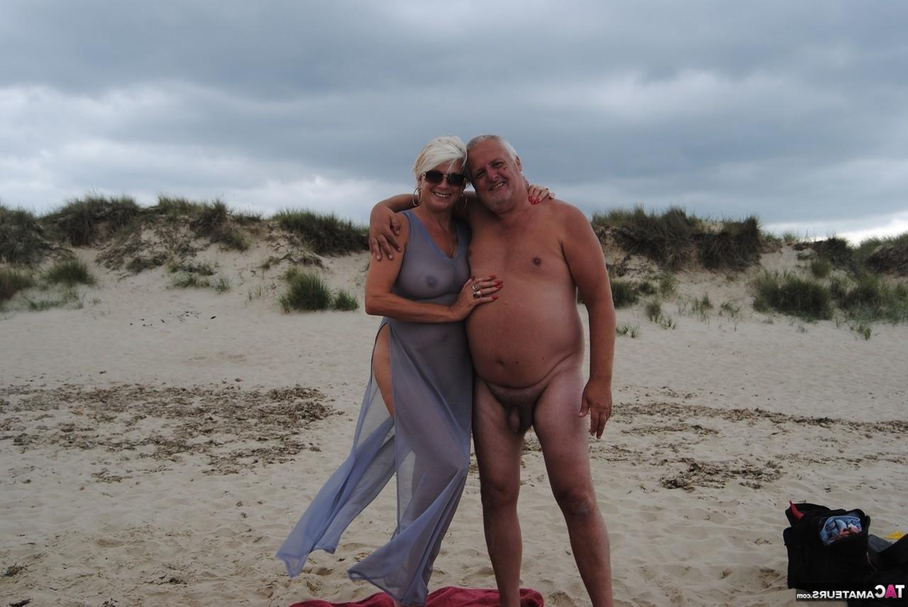 20P Die ältere Platinblondine Dimonty wirft ihrem Mann am FKK-Strand einen Kuss zu