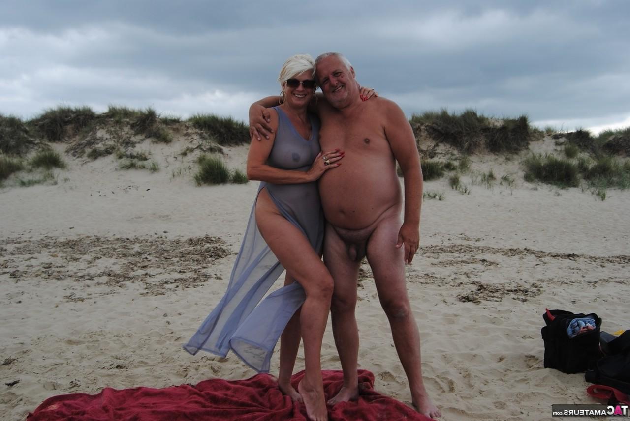 20P Die ältere Platinblondine Dimonty wirft ihrem Mann am FKK-Strand einen Kuss zu