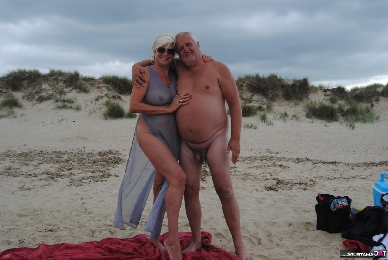 20P Die ältere Platinblondine Dimonty wirft ihrem Mann am FKK-Strand einen Kuss zu
