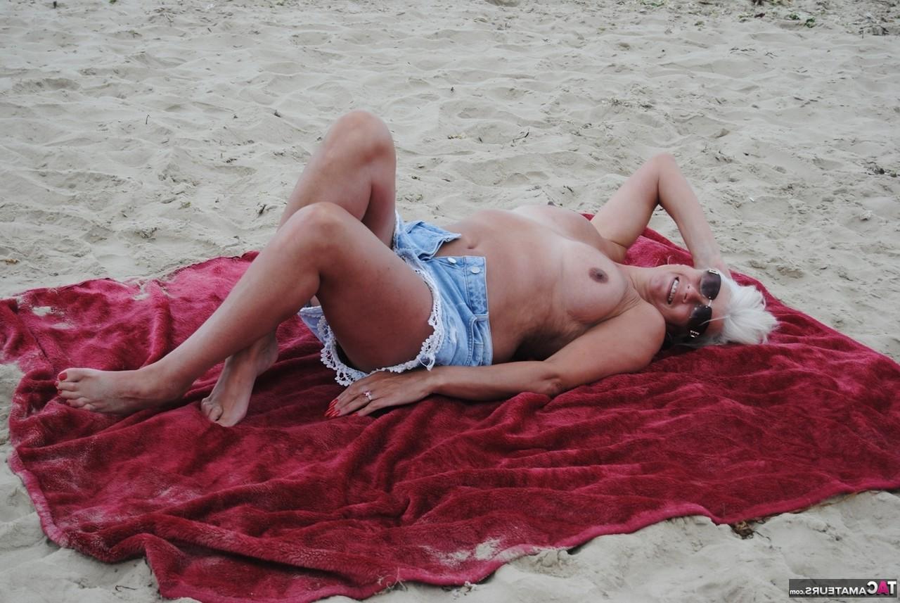 20P Die ältere Platinblondine Dimonty wirft ihrem Mann am FKK-Strand einen Kuss zu