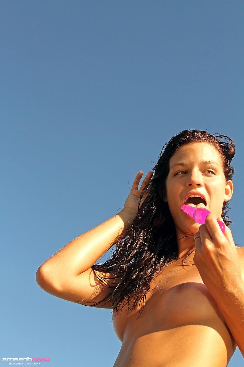 20P A adolescente nua Gia mostra sua buceta raspada de perto enquanto se masturba na praia