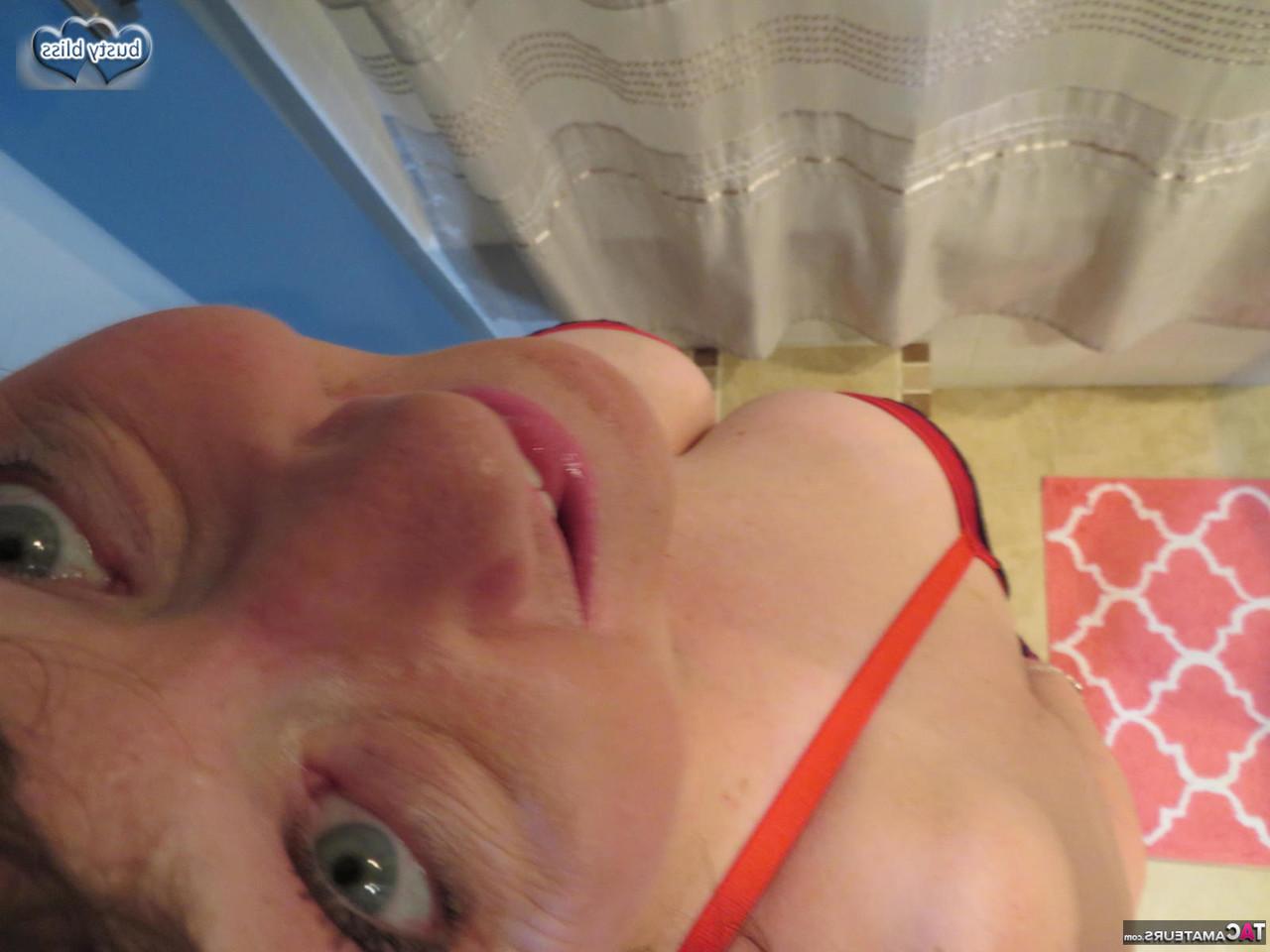 16P Die reife Dame Busty Bliss entblößt ihre großen Titten, während sie lackierte Zehennägel trägt