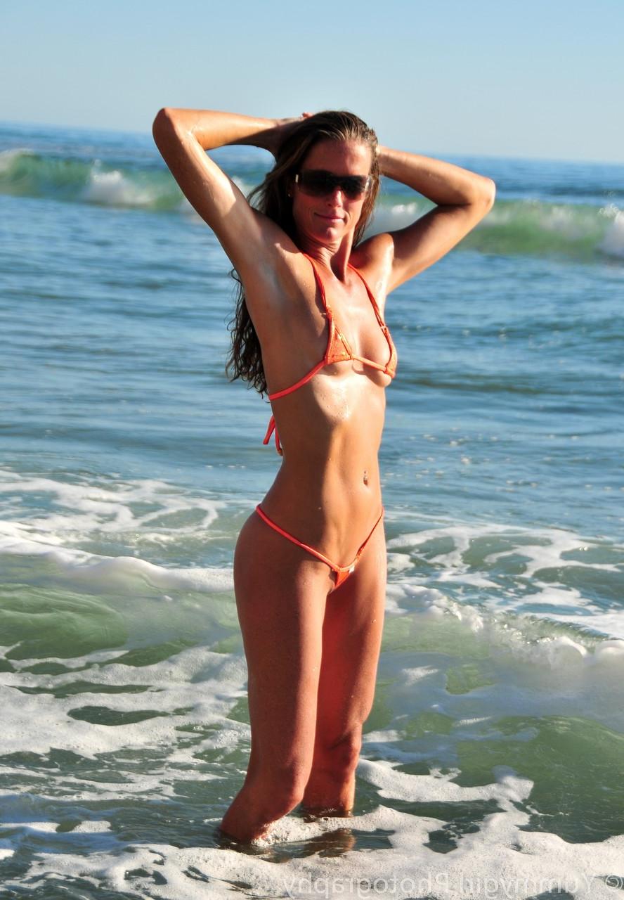 20P La grande MILF Sofie Marie montre son corps élancé dans un bikini étriqué à la plage.