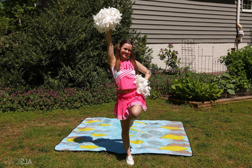 16P Cute cheerleader Trinity Olsen masturbates with a black dildo in a backyard