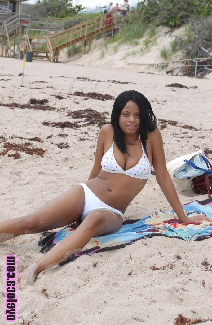 17P La belle jeune ébène Nina Belle aux gros seins se fait bronzer sur la plage en bikini.