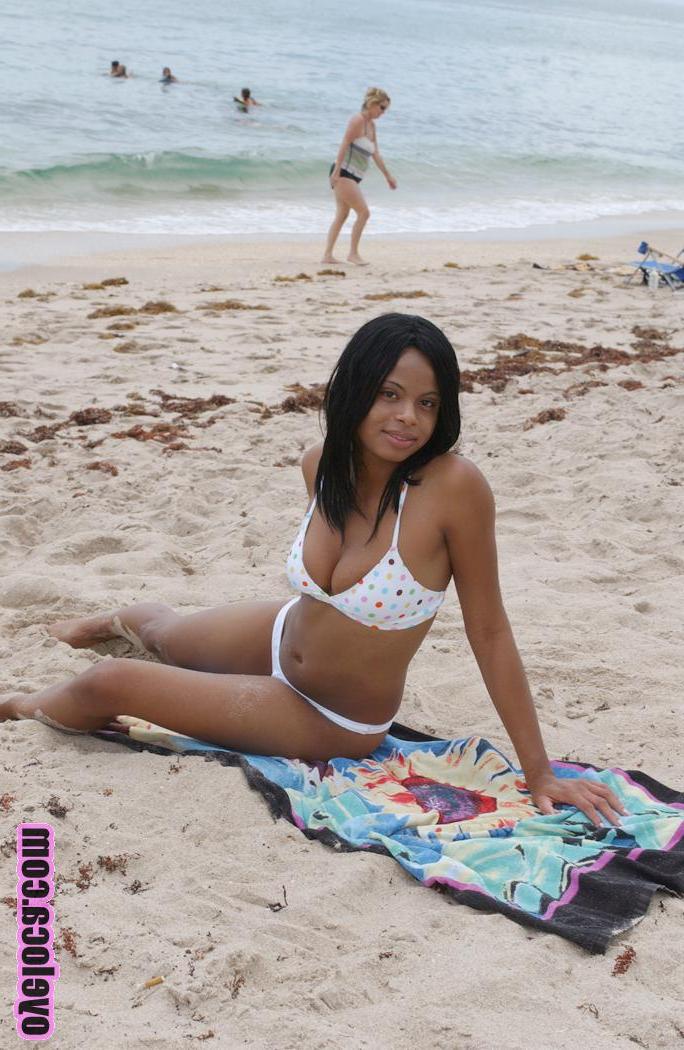 17P La belle jeune ébène Nina Belle aux gros seins se fait bronzer sur la plage en bikini.