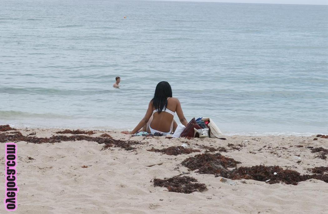 17P La belle jeune ébène Nina Belle aux gros seins se fait bronzer sur la plage en bikini.