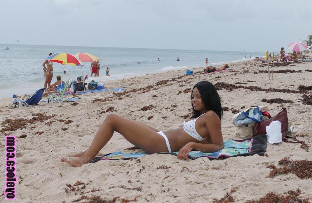 17P La belle jeune ébène Nina Belle aux gros seins se fait bronzer sur la plage en bikini.
