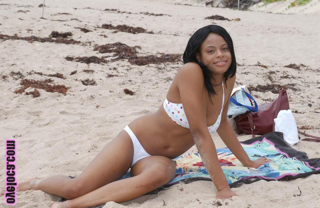 17P La belle jeune ébène Nina Belle aux gros seins se fait bronzer sur la plage en bikini.