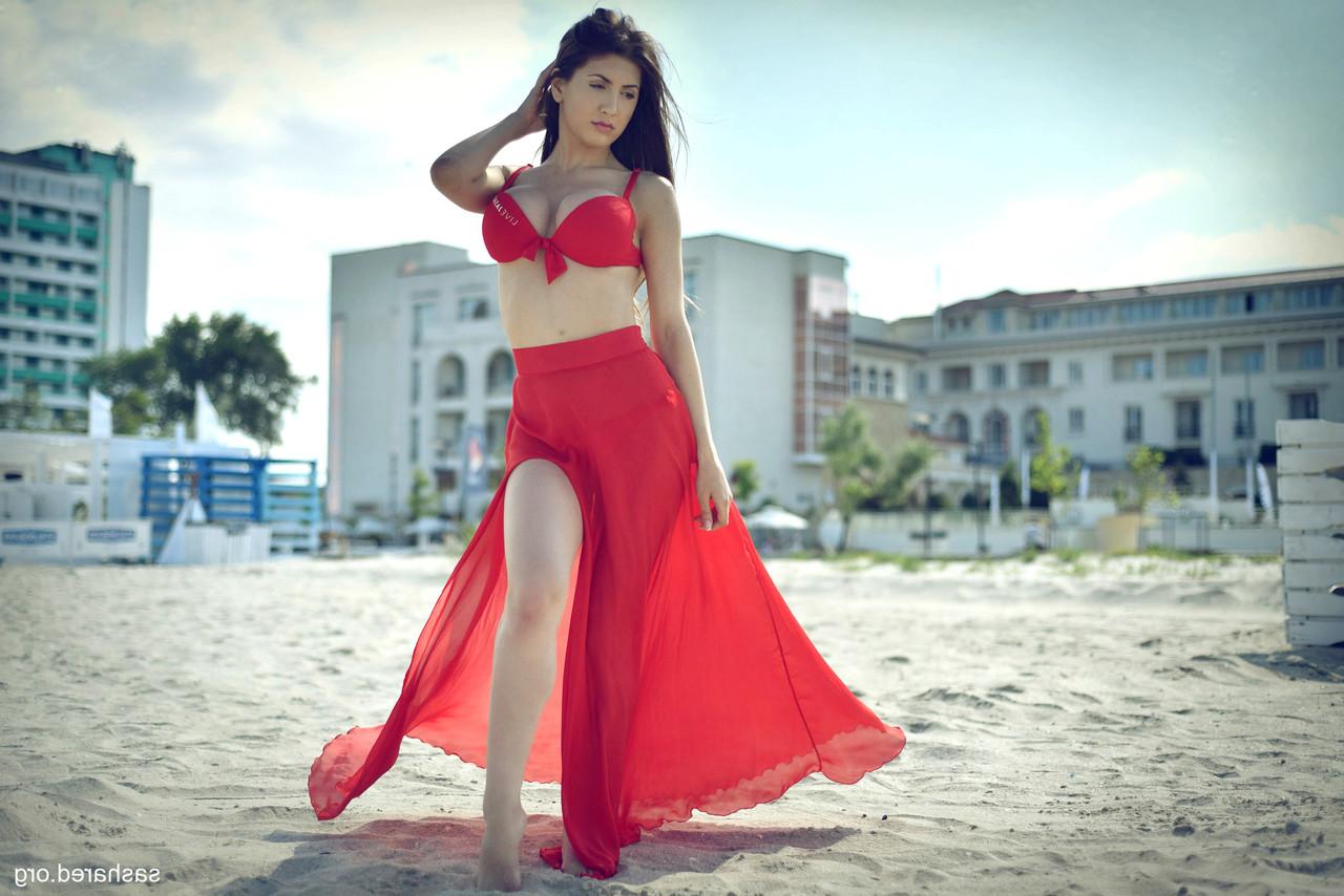 15P A esbelta gata amadora Sasha Red posando em seu biquíni vermelho na praia