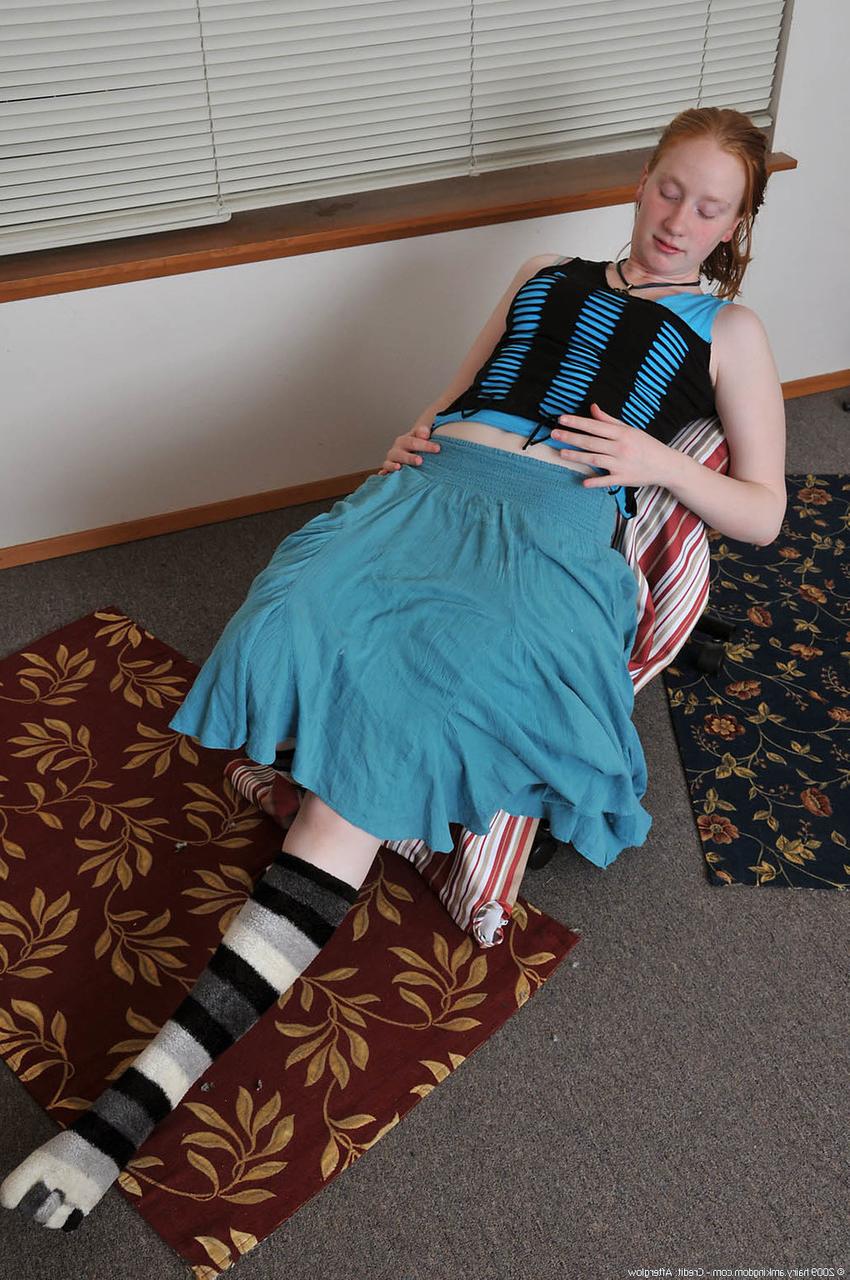 20P Redheaded babe Sandy shows her small teen tits while undressing