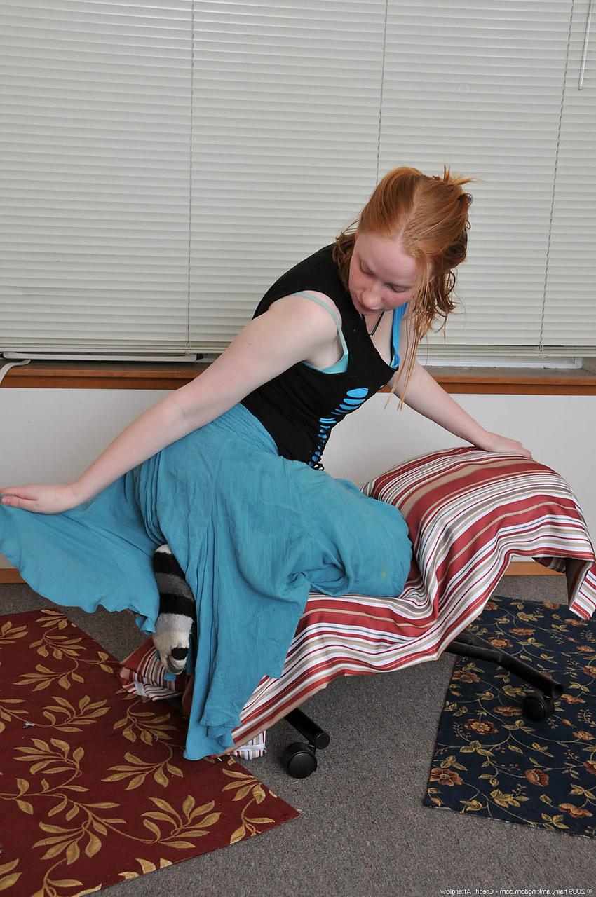20P Redheaded babe Sandy shows her small teen tits while undressing