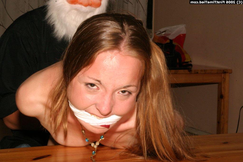 12P Une amatrice est menottée et bâillonnée par un homme portant un masque de Père Noël.