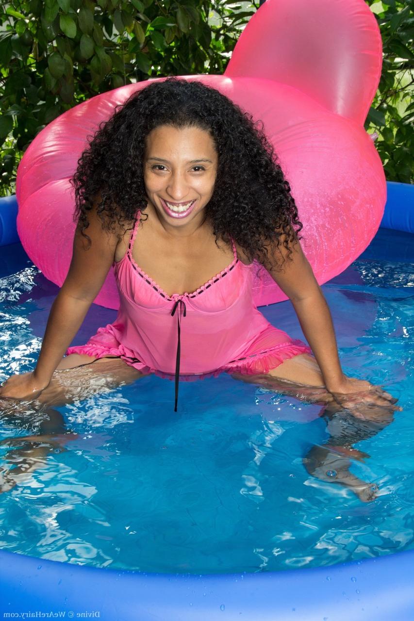 20P La beauté noire Divine se déshabille à la piscine et exhibe sa chatte poilue.