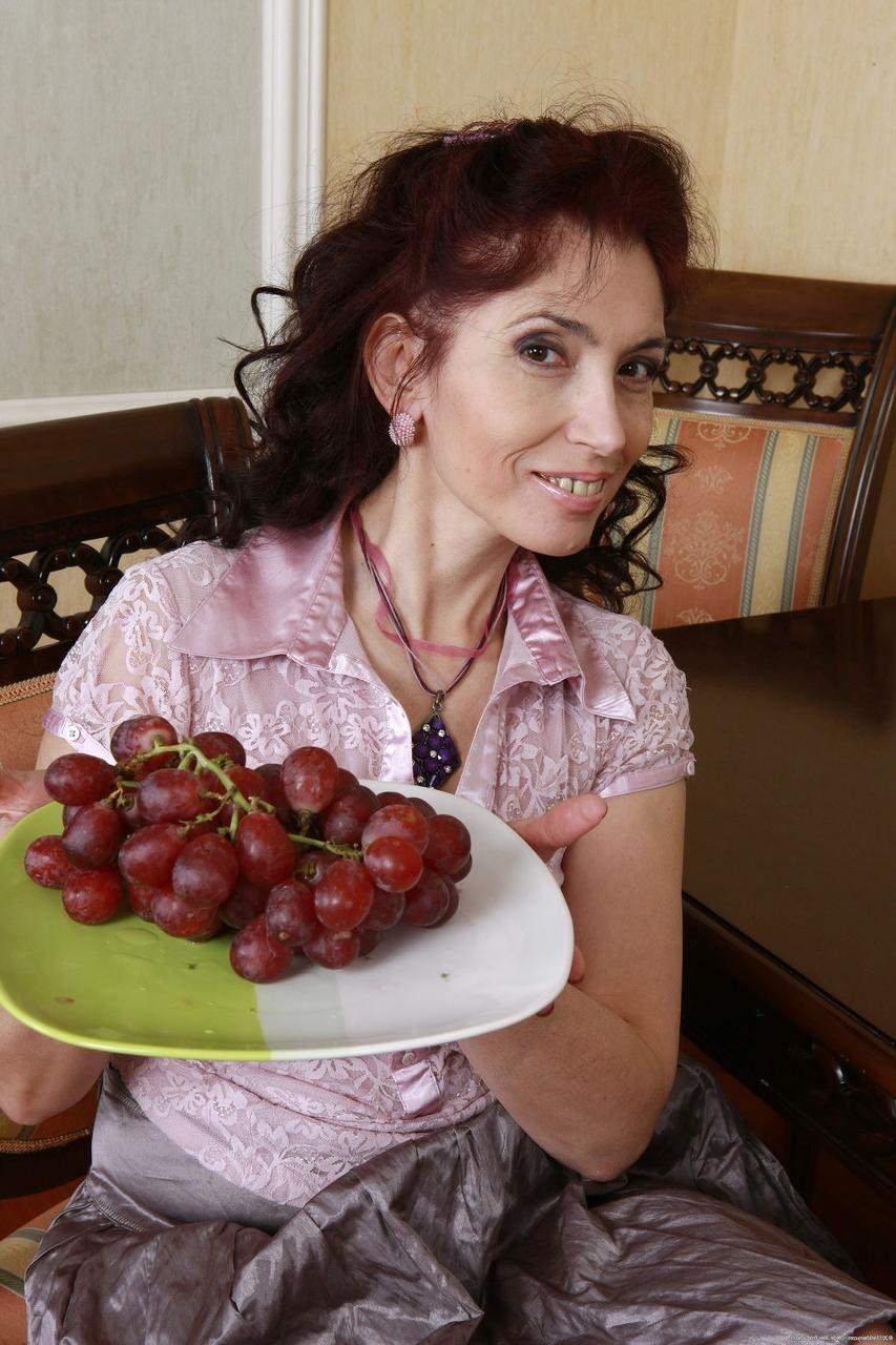 20P Une maman russe aux gros seins se déshabille et frotte sa chatte poilue en mangeant du raisin