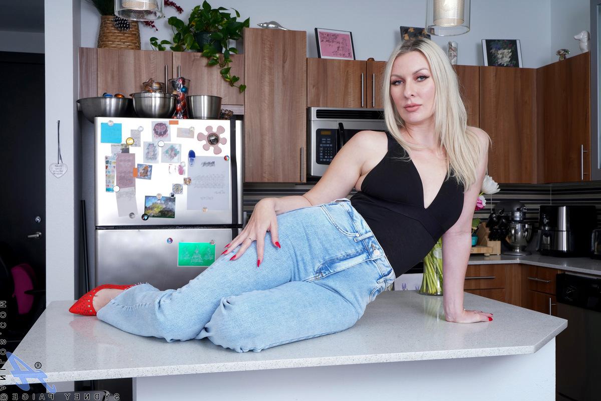 16P La blonde amateur Sydney Paige étale sa chatte rose et serrée sur un îlot de cuisine.