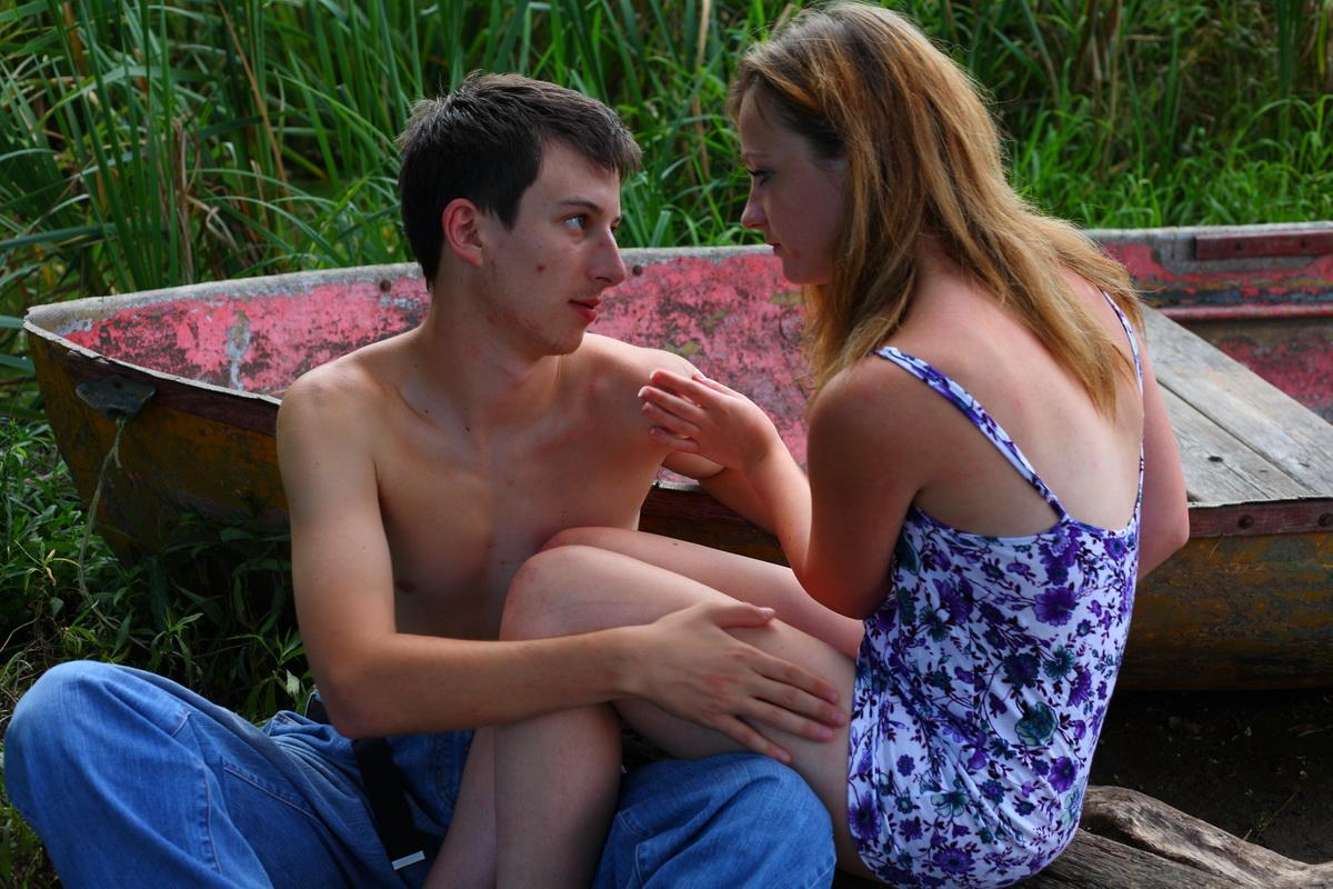 15P Jeune rousse et son petit ami font l'amour sur un terrain herbeux près de l'eau