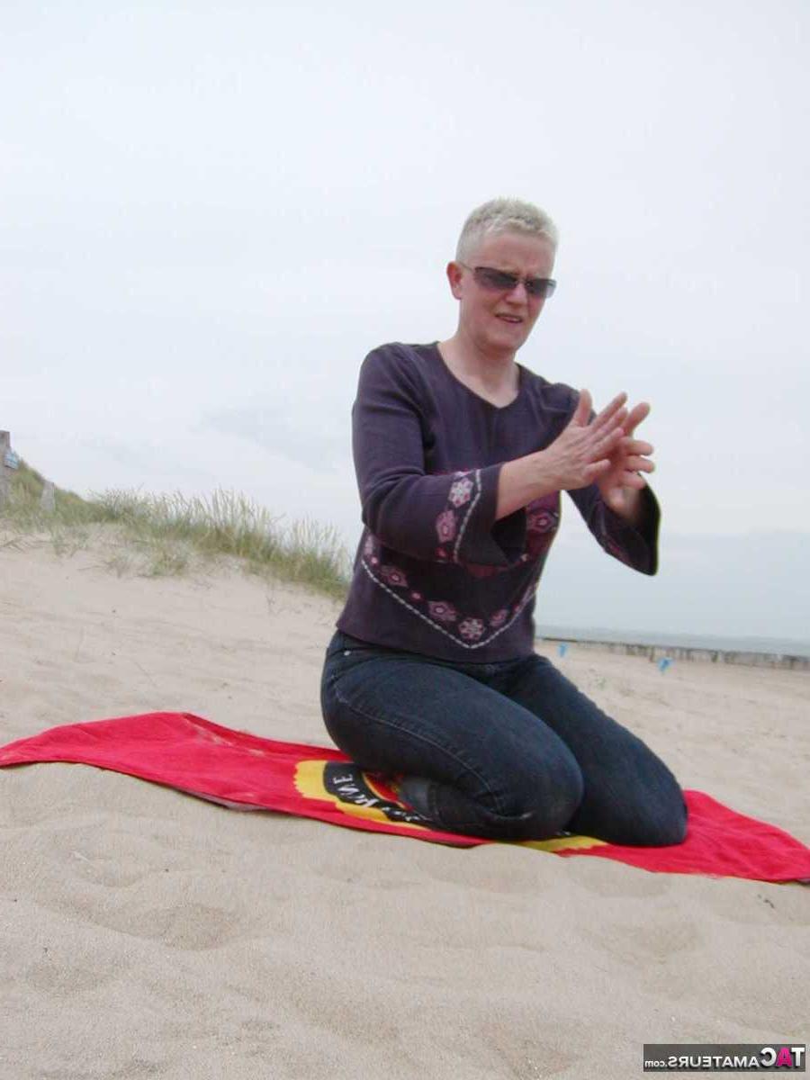 15P La blonde plus âgée Tiffany Pearl se met nue à la plage sur une serviette.