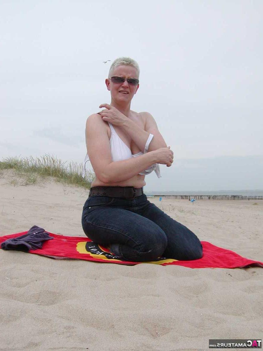 15P La blonde plus âgée Tiffany Pearl se met nue à la plage sur une serviette.