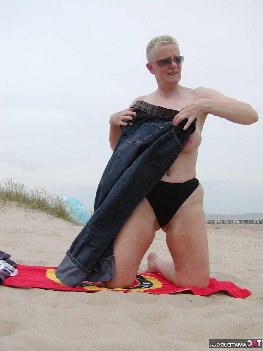 15P La blonde plus âgée Tiffany Pearl se met nue à la plage sur une serviette.