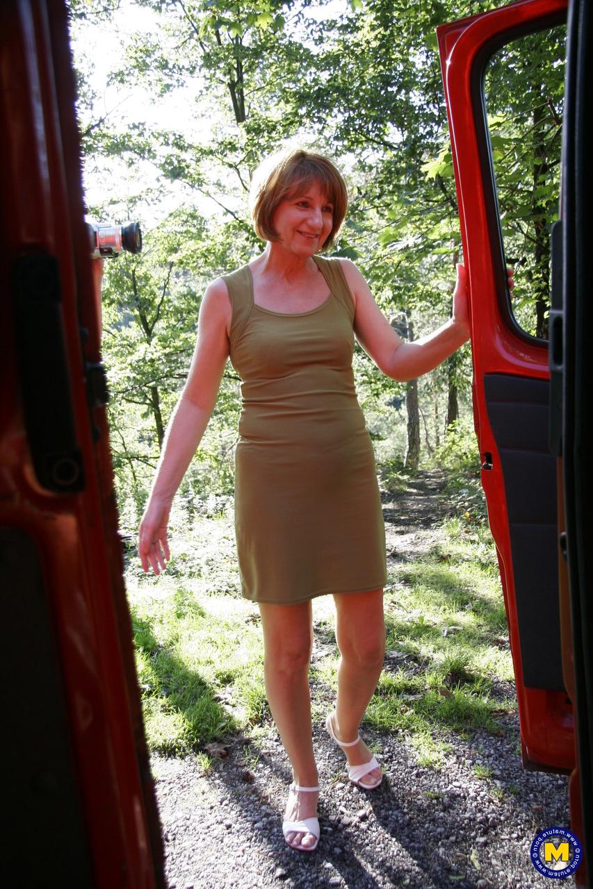 20P Yvonne, une femme européenne mature, souffle sur deux adolescents en plein air.