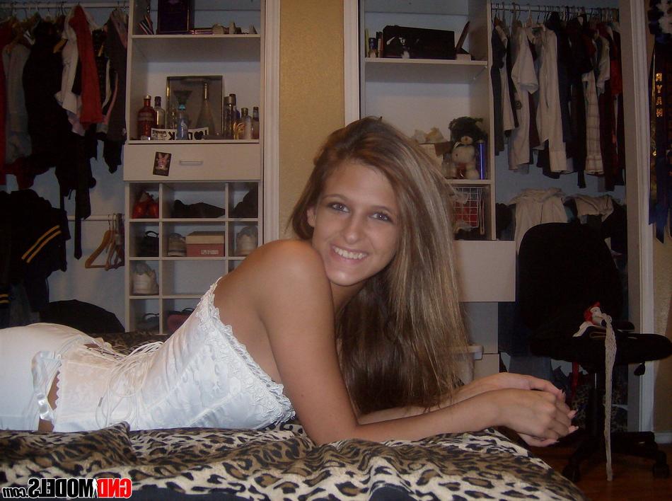 12P A modelo amadora Adri posa em casa com um espartilho branco e meia-calça