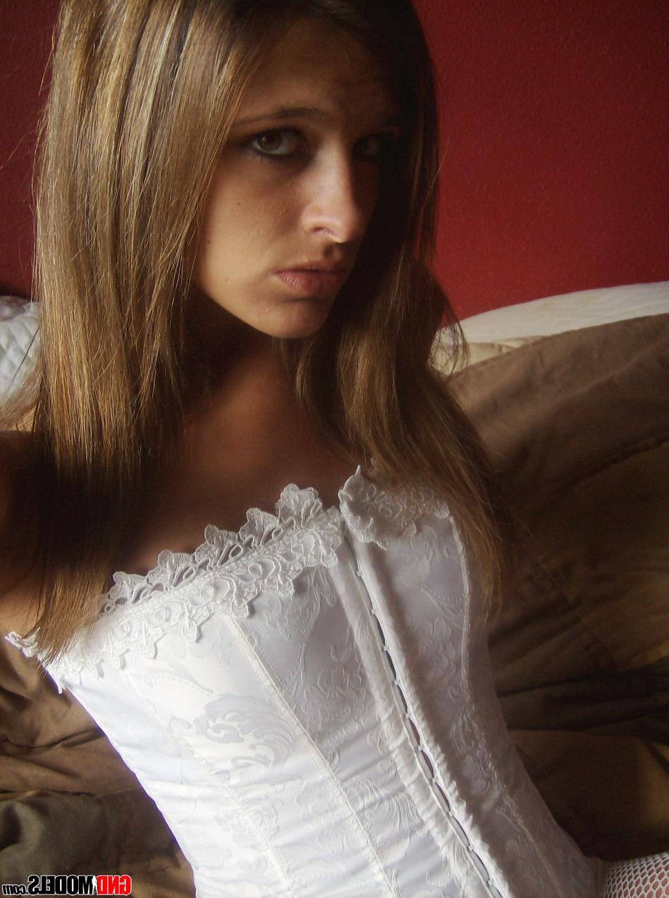 12P A modelo amadora Adri posa em casa com um espartilho branco e meia-calça