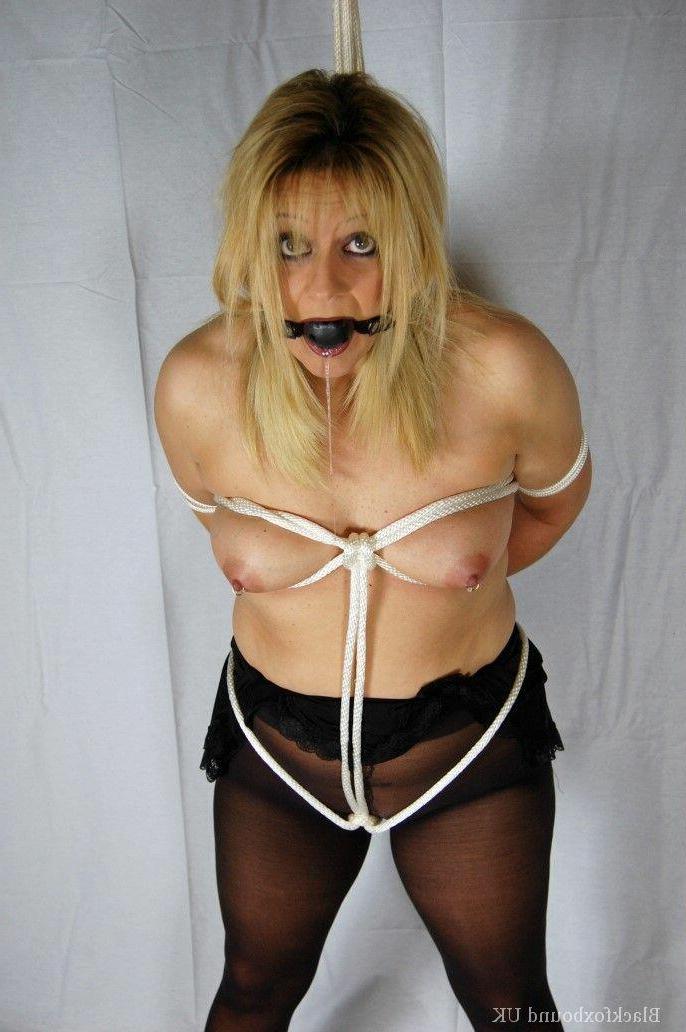 15P Rubia en topless luce una mordaza de bola con las manos atadas a la espalda con mangueras