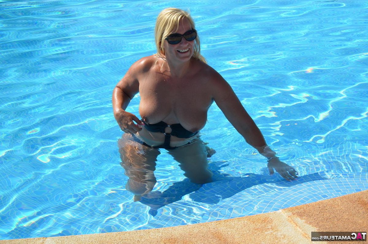16P A loira de meia-idade, Sweet Susi, libera seus peitos e buceta de um maiô à beira da piscina