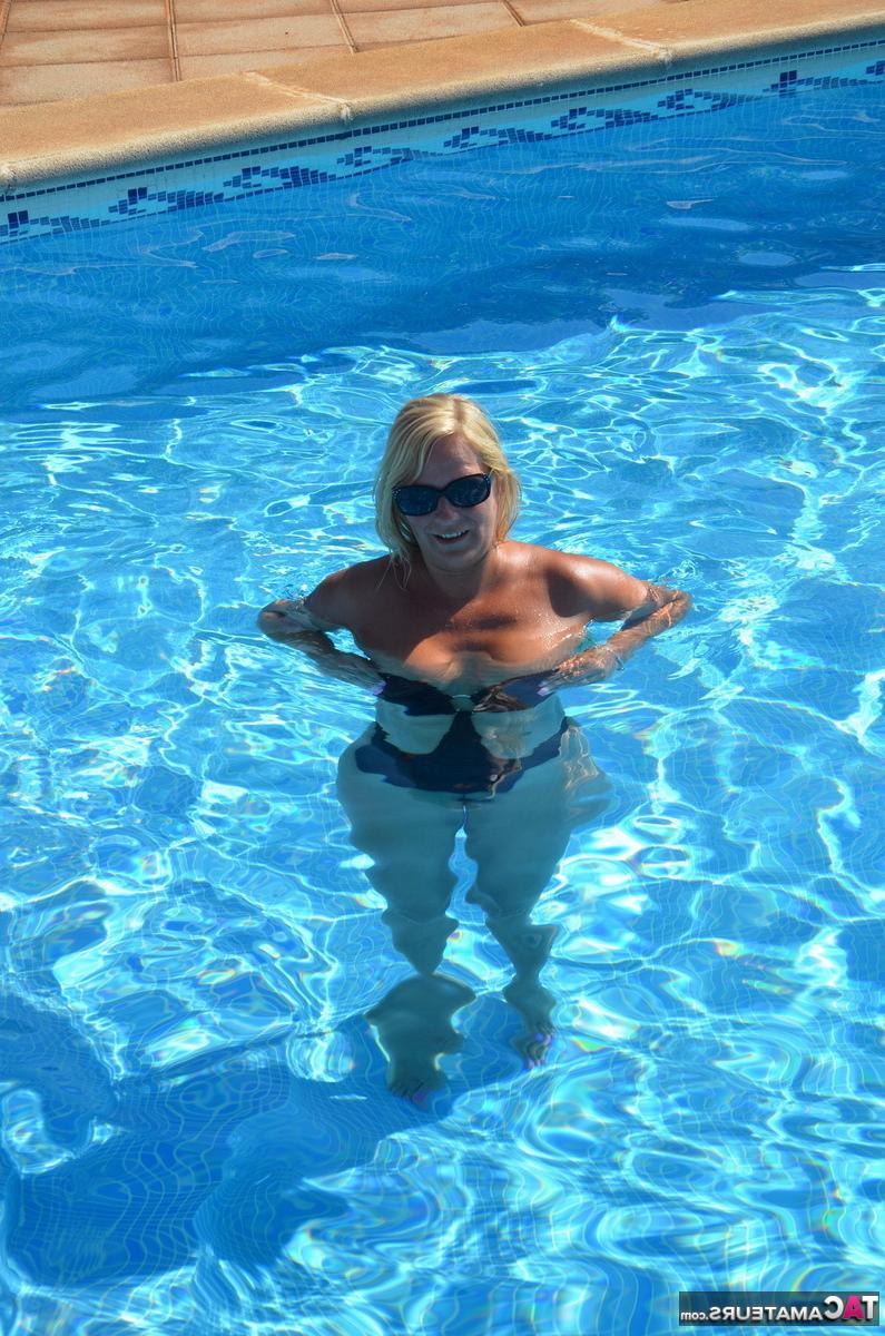 16P A loira de meia-idade, Sweet Susi, libera seus peitos e buceta de um maiô à beira da piscina