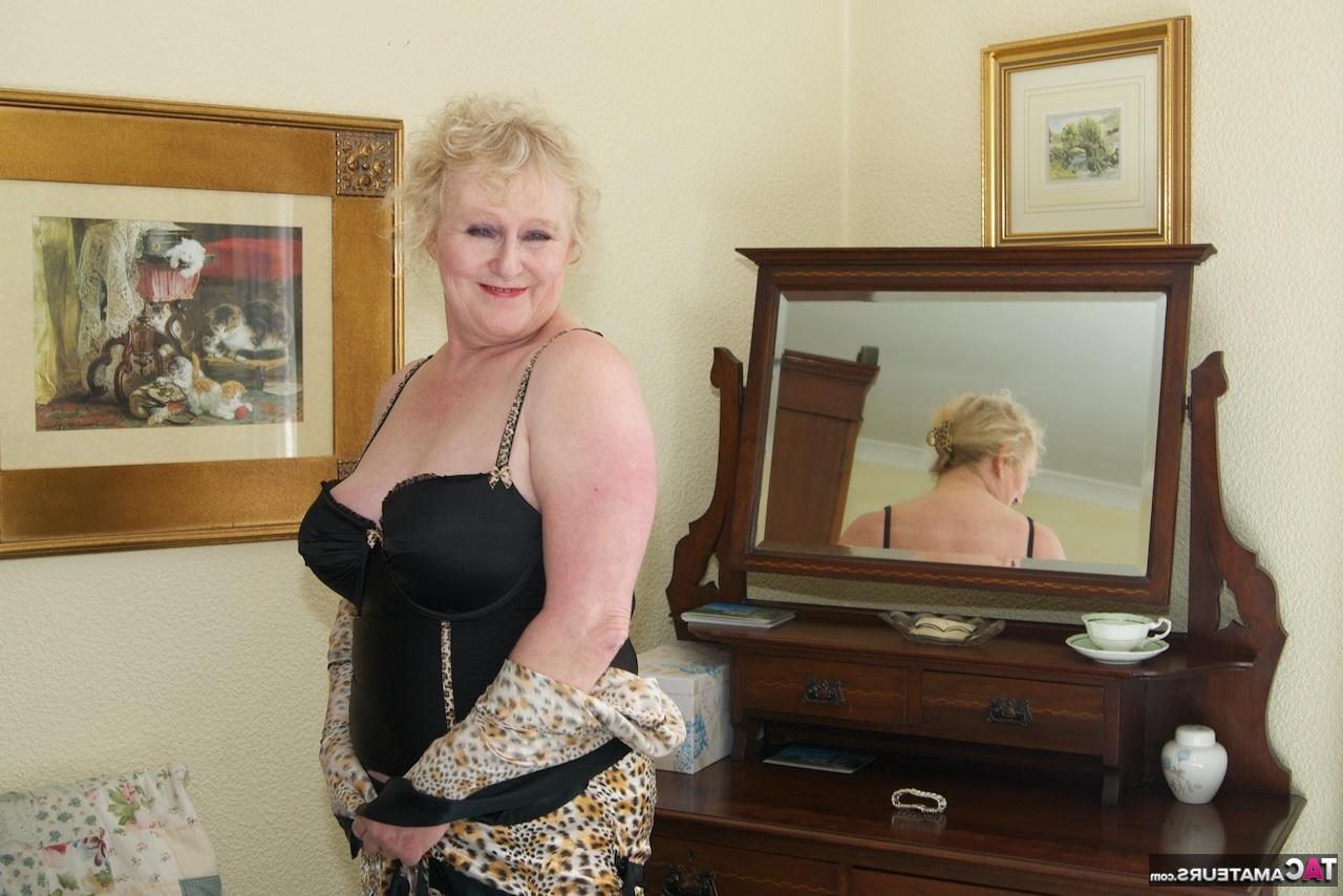 16P Mamie blonde s'admire dans un miroir tout en portant de la lingerie et des bas de nylon