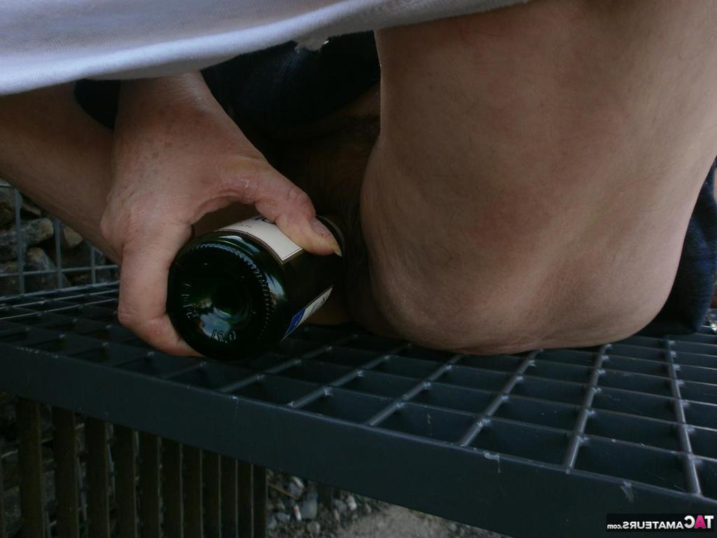 20P A velha e excitada Caro ao ar livre com botas espalhando a buceta para brincar com uma garrafa de vinho
