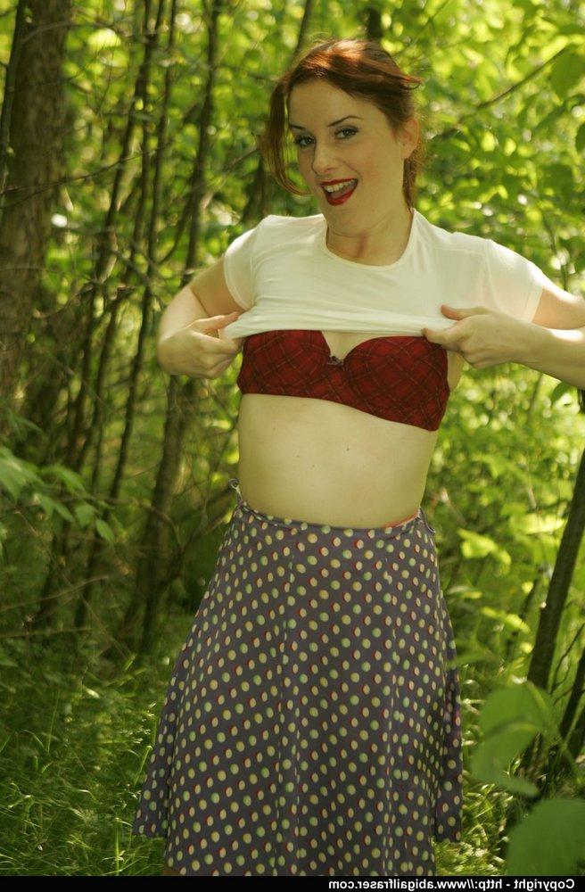 12P Une amatrice rousse enlève sa culotte en satin dans les bois avant de s'habiller.