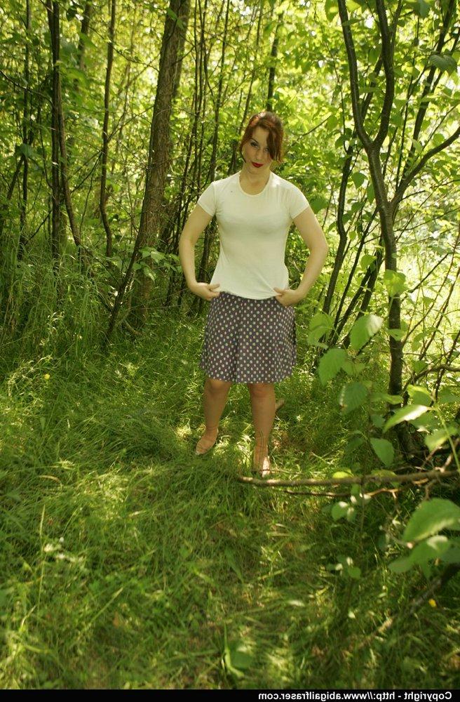 12P Une amatrice rousse enlève sa culotte en satin dans les bois avant de s'habiller.