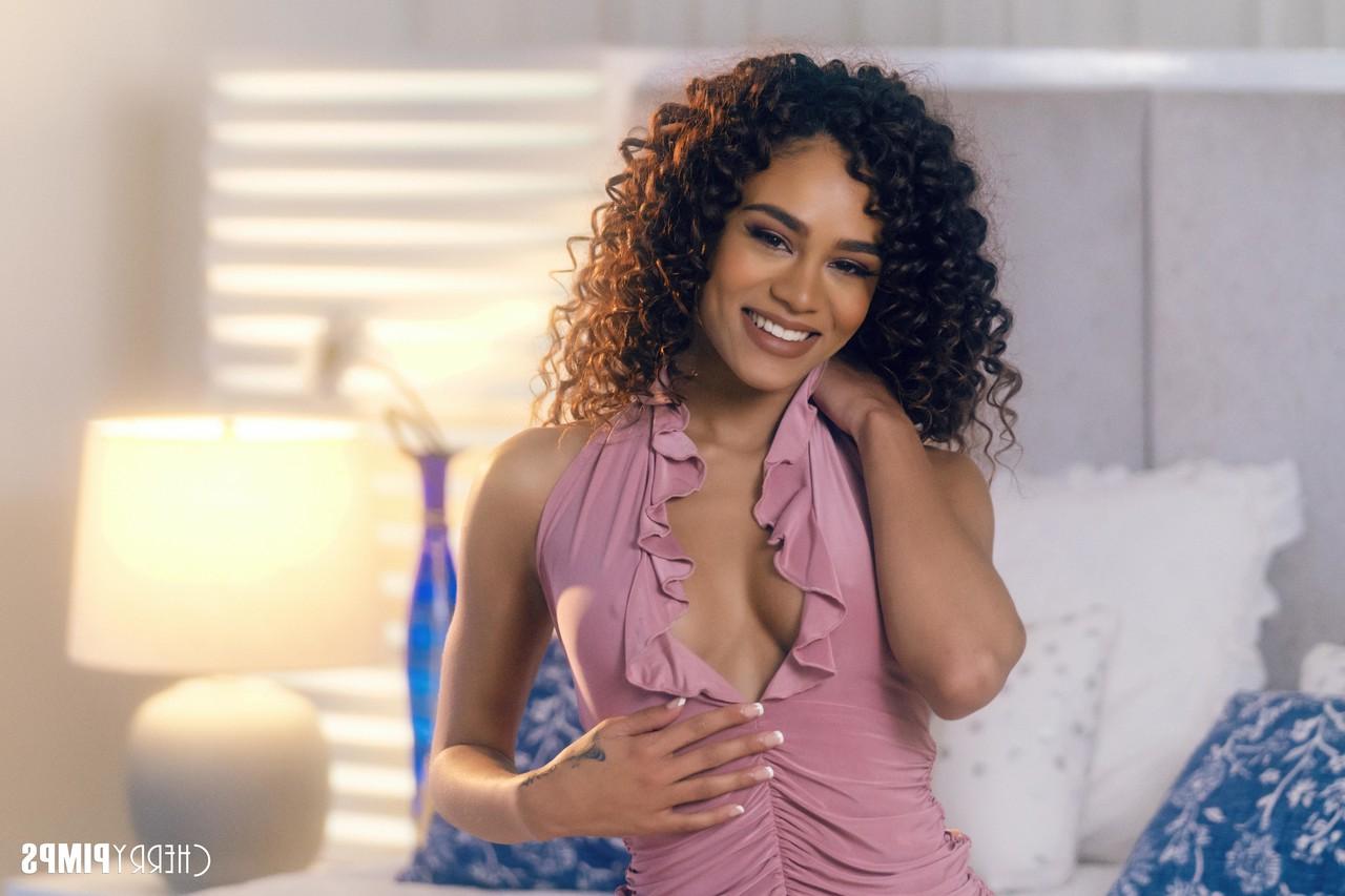 16P Curly-haired ebony Scarlit Scandal posing in her sexy purple dress