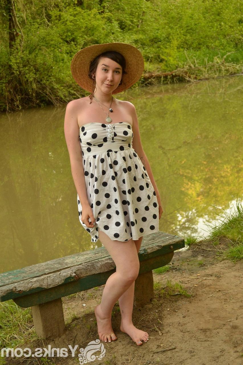 17P Versautes Mädchen mit Strohhut zieht ihr Kleid aus, um am Fluss mit den Fingern zu ficken