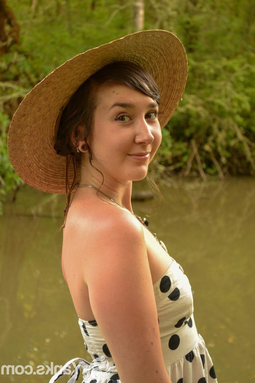 17P Versautes Mädchen mit Strohhut zieht ihr Kleid aus, um am Fluss mit den Fingern zu ficken