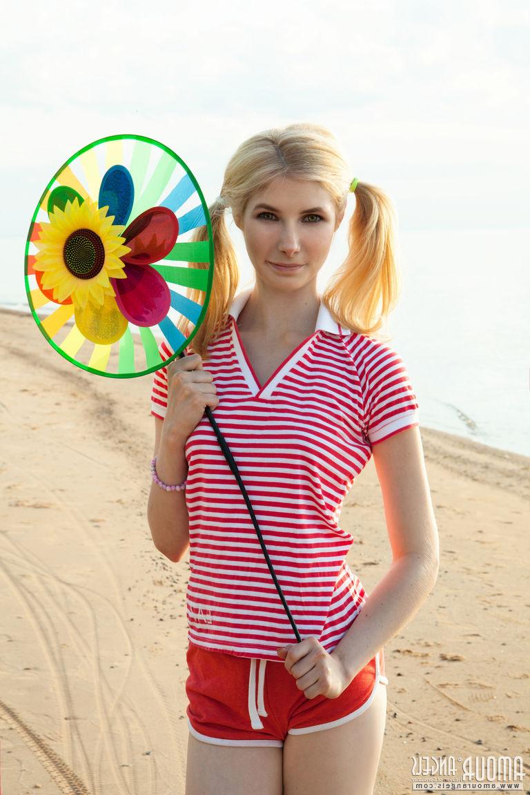 20P Die zierliche blonde Teenagerin Candy präsentiert ihre Muschi nackt auf einem Strandtuch