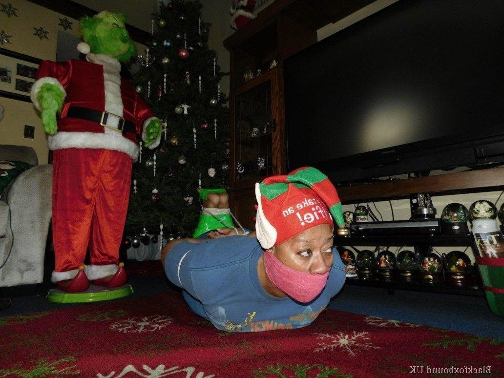 16P Mulher negra se vê amordaçada e amarrada em frente a uma árvore de Natal