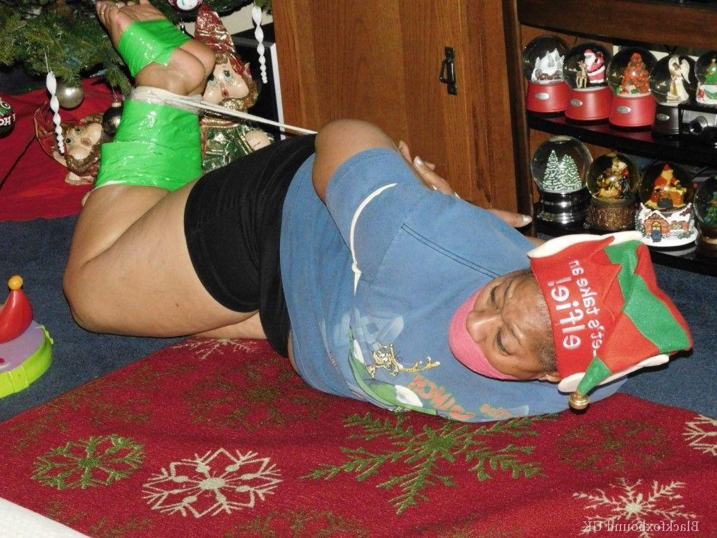 16P Mulher negra se vê amordaçada e amarrada em frente a uma árvore de Natal