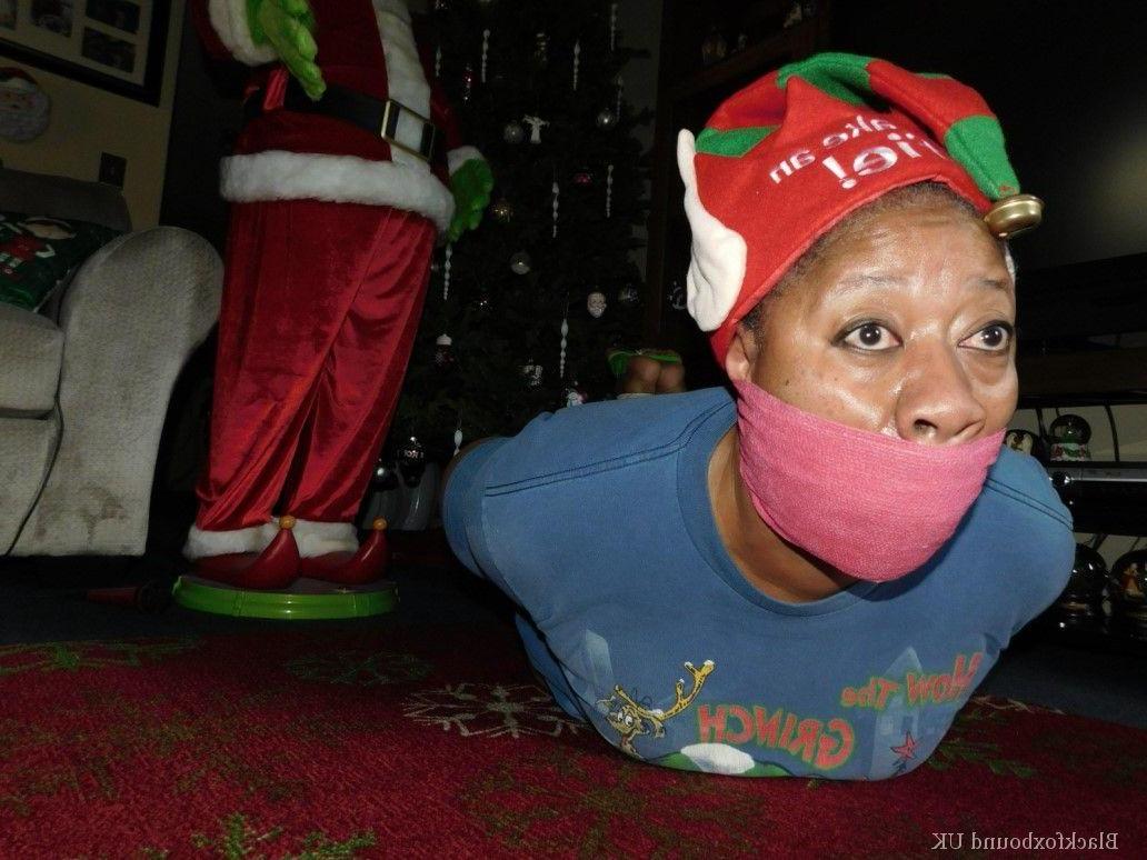 16P Mulher negra se vê amordaçada e amarrada em frente a uma árvore de Natal