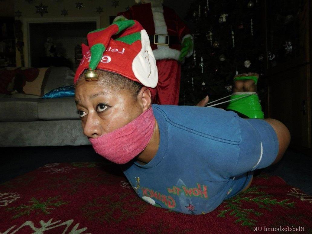 16P Mulher negra se vê amordaçada e amarrada em frente a uma árvore de Natal