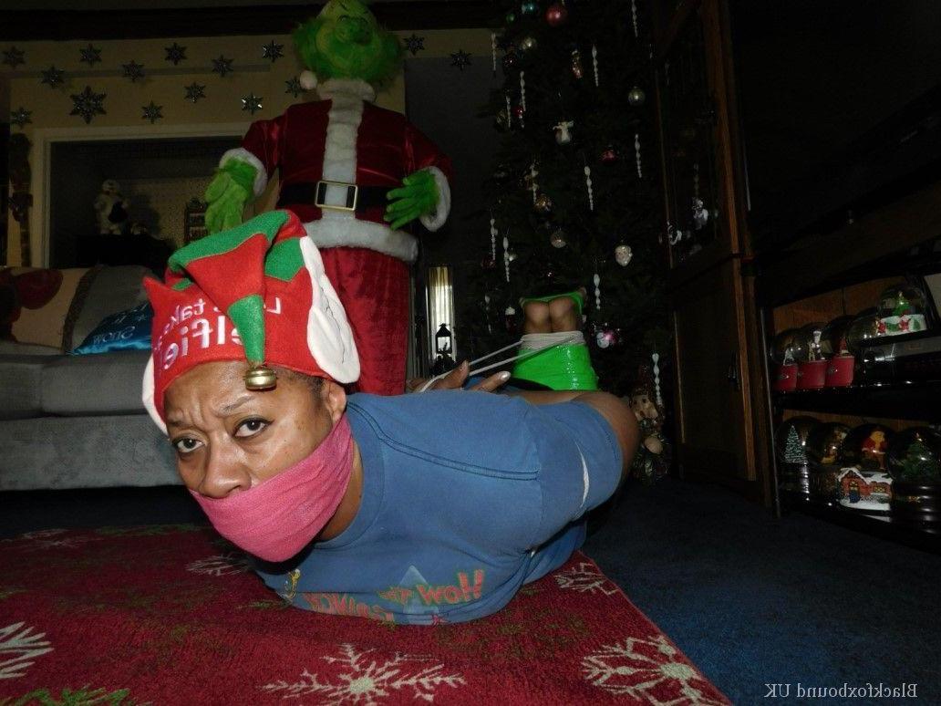 16P Mulher negra se vê amordaçada e amarrada em frente a uma árvore de Natal