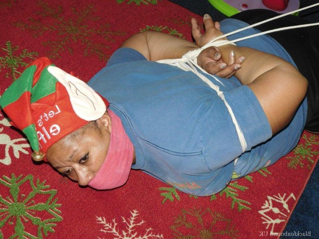 16P Mulher negra se vê amordaçada e amarrada em frente a uma árvore de Natal