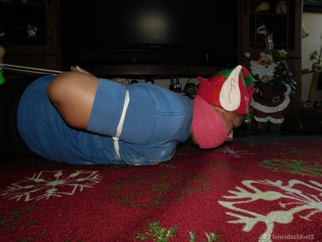 16P Mulher negra se vê amordaçada e amarrada em frente a uma árvore de Natal