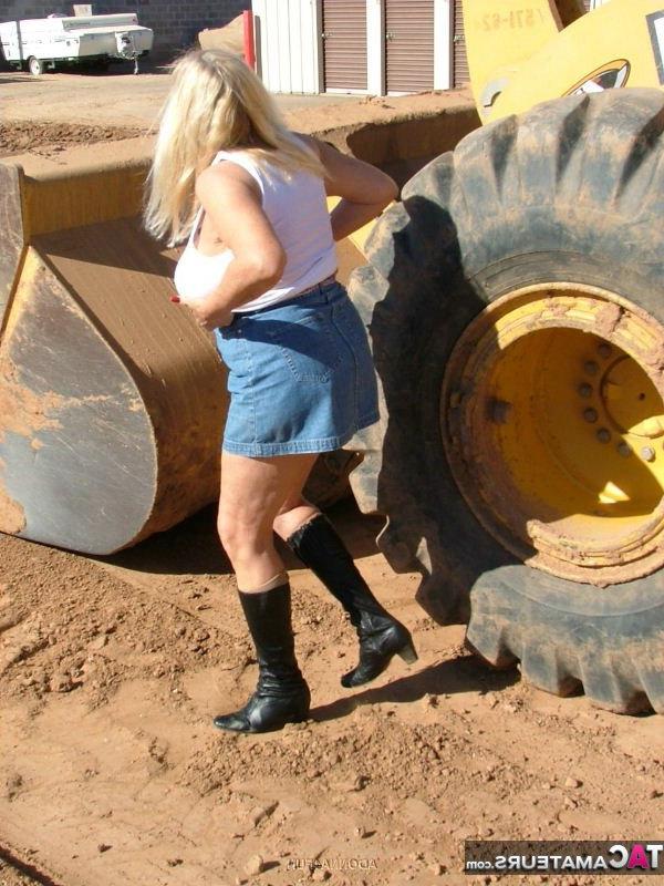 19P Adonna loira madura com excesso de peso se expõe na frente de equipamentos pesados