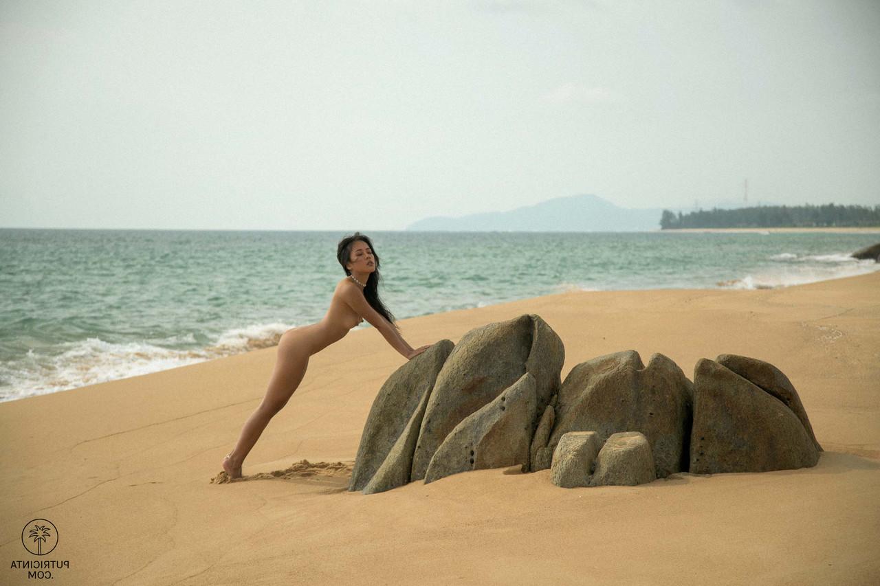 20P Petite morena Asian babe Danie Jane posa nua em uma praia de areia