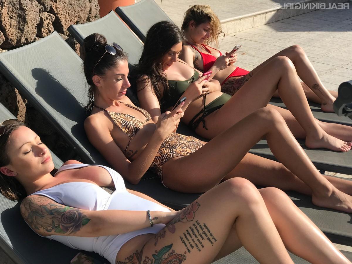 15P Vier Mädchen ziehen beim Sonnenbaden auf Liegestühlen ihre Bikinioberteile aus