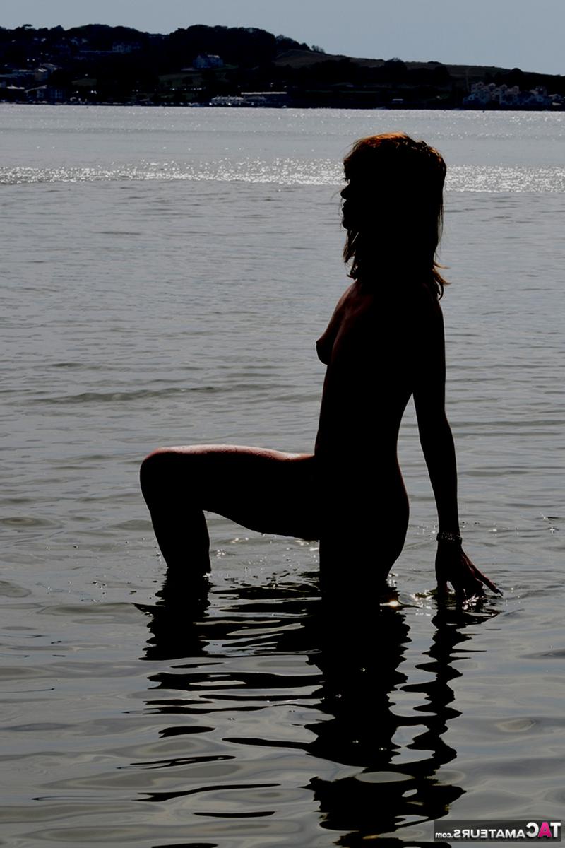 20P Schlankes Mädchen lässt ihre High Heels und ihren Badeanzug am Strand zurück, um nackt ins Meer zu gehen